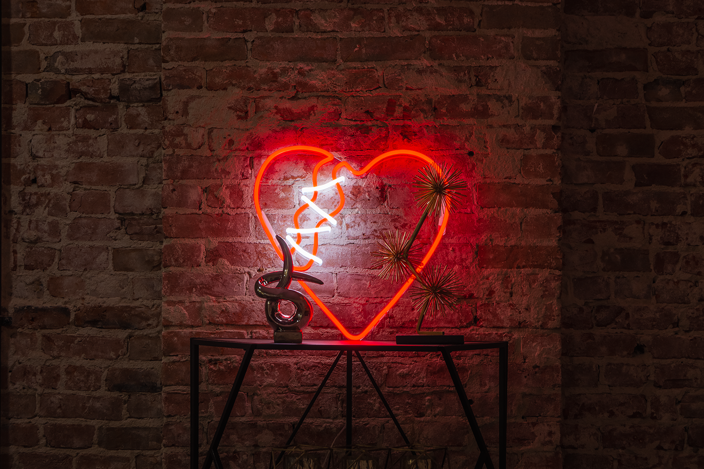 a red neon sign of a broken heart in front of a tile wall