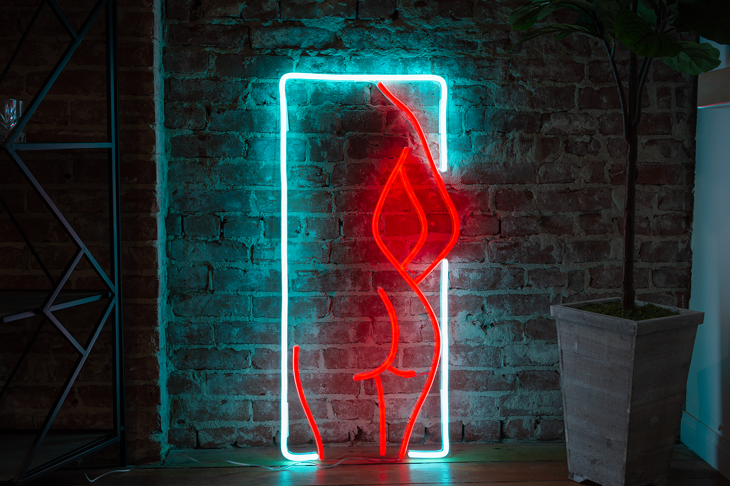 Neon sign of an outline of a woman, leaning on a tile wall.