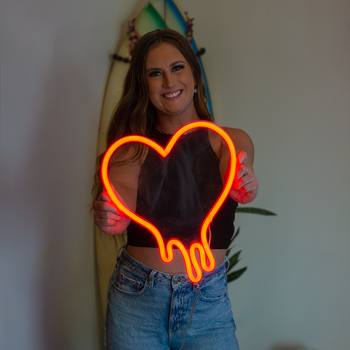 Girl holding a red heart neon sign