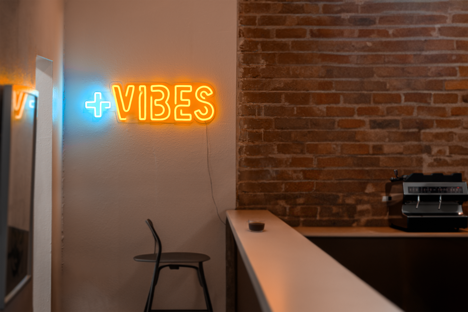 an orange neon sign that says "positive vibes"