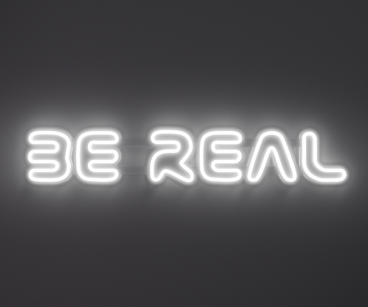white neon sign that says be real