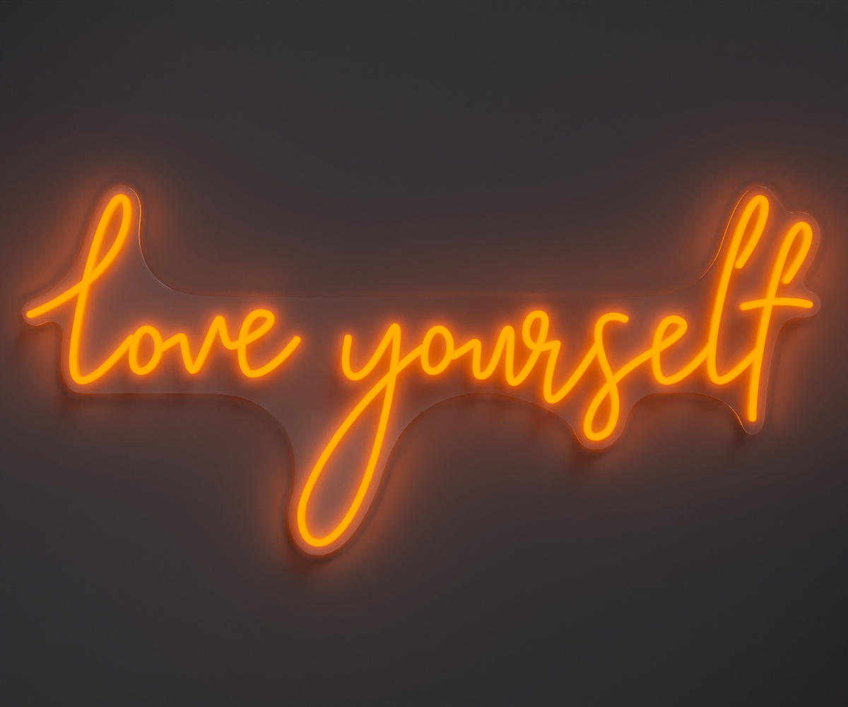 orange neon sign that says love yourself