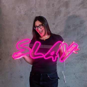A pink neon sign that says "slay"
