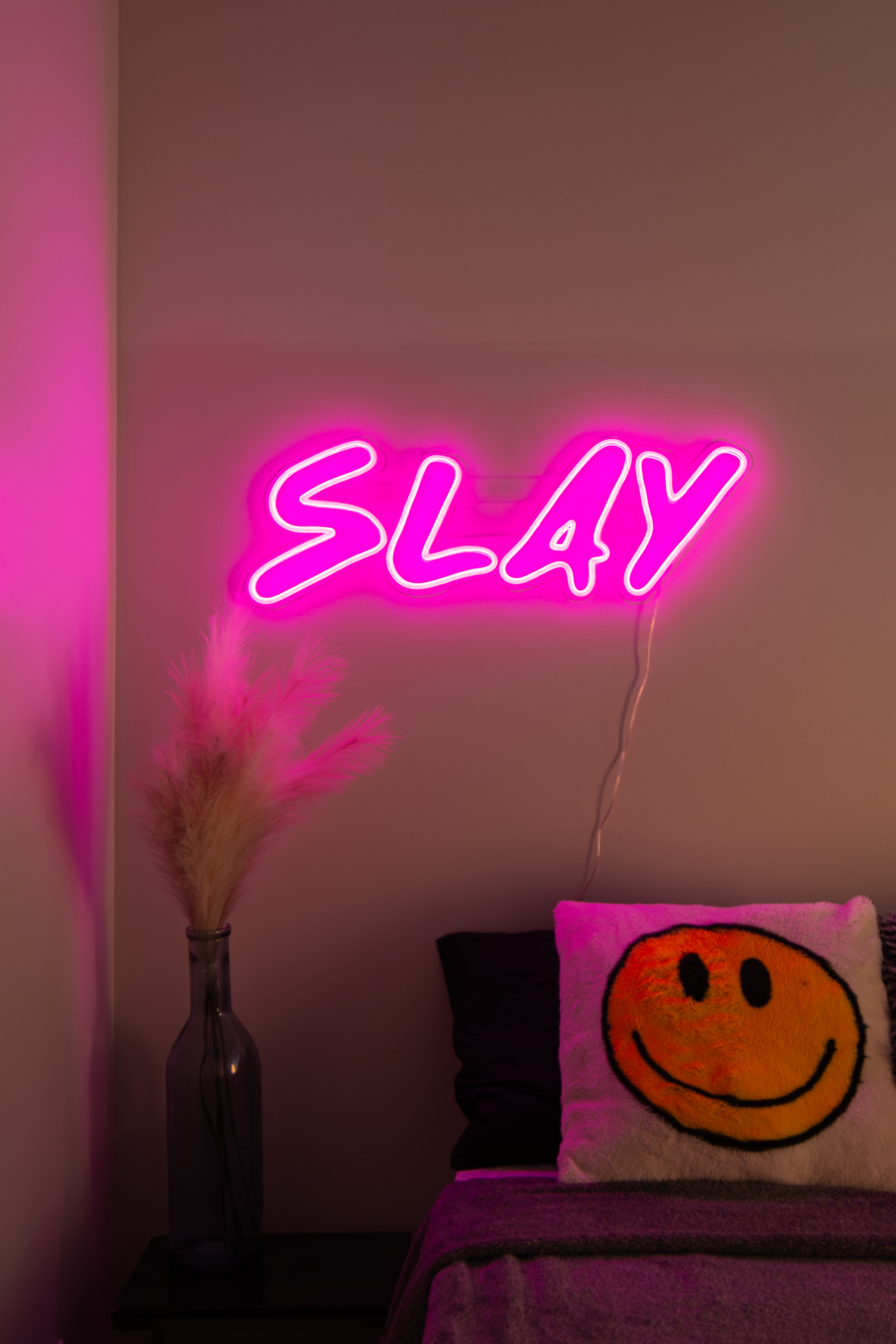 A pink 'slay' neon sign in bedroom